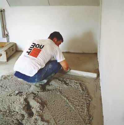 mężczyzna betonuje podłogę, logo Baumit